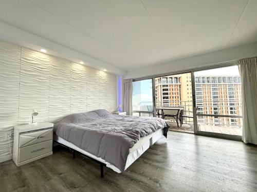 a bedroom with a large bed and a large window at Ilikai Apt 1822 - Newly Renovated 2BR 2BA Modern Unit with Stunning Ocean & Harbor Views in Honolulu