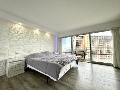 een slaapkamer met een groot bed en een groot raam bij Ilikai Apt 1822 - Newly Renovated 2BR 2BA Modern Unit with Stunning Ocean & Harbor Views in Honolulu