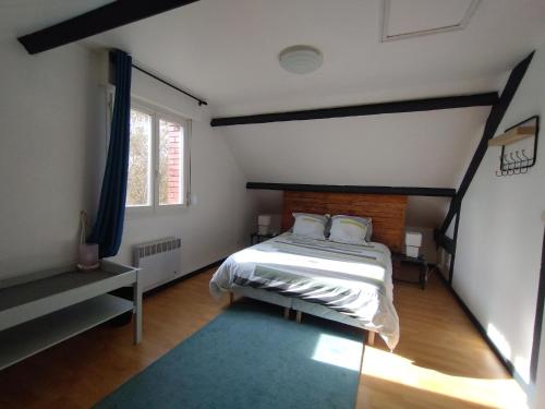 a bedroom with a bed and a large window at Cottage Centulois in Saint-Riquier