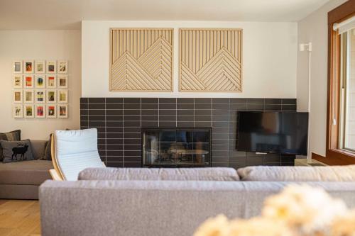 a living room with two couches and a fireplace at Chic Bend Condo with Fireplace and Forest Views! in Bend