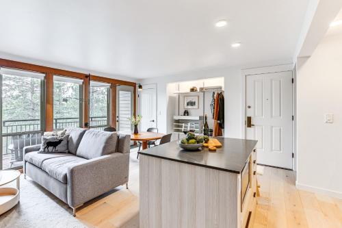 a kitchen and living room with a couch and a table at Chic Bend Condo with Fireplace and Forest Views! in Bend