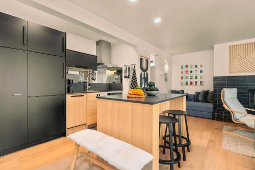 a kitchen with a counter and some chairs in a room at Chic Bend Condo with Fireplace and Forest Views! in Bend