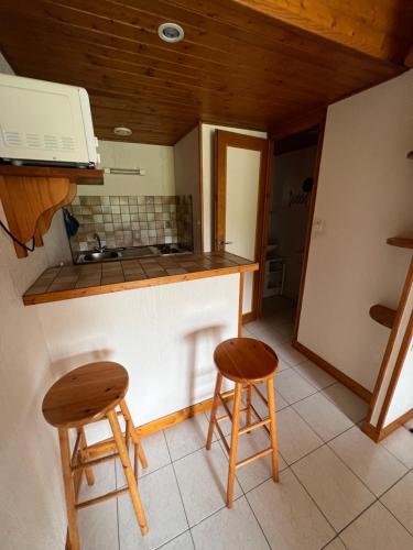 uma cozinha com dois bancos e um balcão em Chez Laurie et Xavier studio 1 em Mignaloux-Beauvoir
