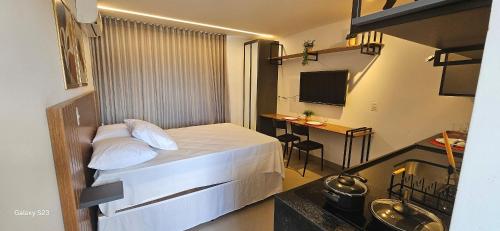 a hotel room with a bed and a desk at Flats Tramonto - By EasyHost in João Pessoa