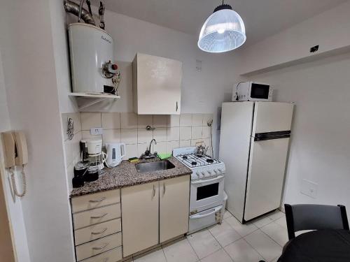 eine Küche mit einem weißen Kühlschrank und einer Spüle in der Unterkunft Bahía x día 1 in Bahía Blanca