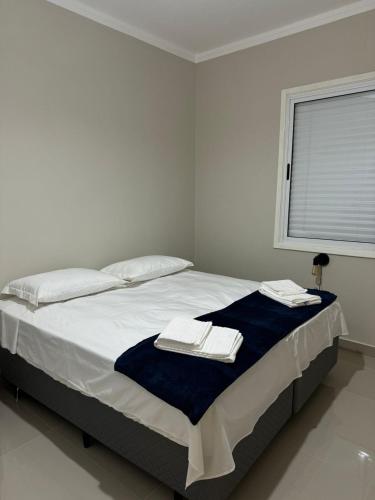 フランカにあるFantastico apto no Centro!の白いベッドルーム(ベッド1台、タオル2枚付)