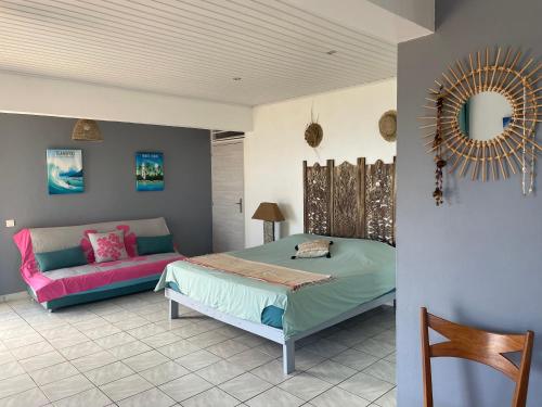 1 dormitorio con 1 cama y 1 sofá en Globe trotter Lodge Tahiti en Punaauia