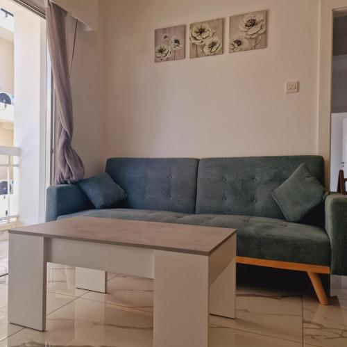 - un salon avec un canapé bleu et une table dans l'établissement Cozy 1 bedroom apartment Larnaca city-center F, à Larnaka