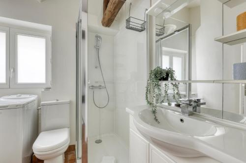 une salle de bain blanche avec un lavabo et des toilettes dans l'établissement Homely & Pleasant T2 flat in the Heart of Paris, à Paris