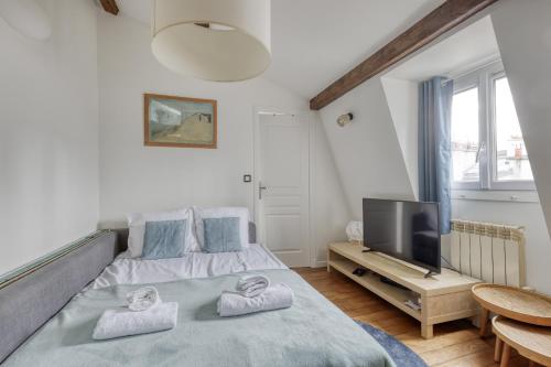 une chambre avec un lit et une télévision à écran plat dans l'établissement Homely & Pleasant T2 flat in the Heart of Paris, à Paris