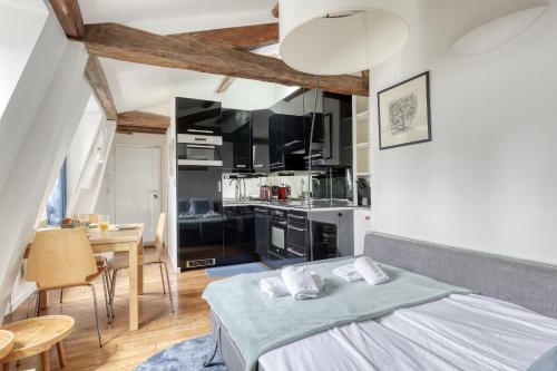 une chambre avec un lit et une table et une cuisine dans l'établissement Homely & Pleasant T2 flat in the Heart of Paris, à Paris