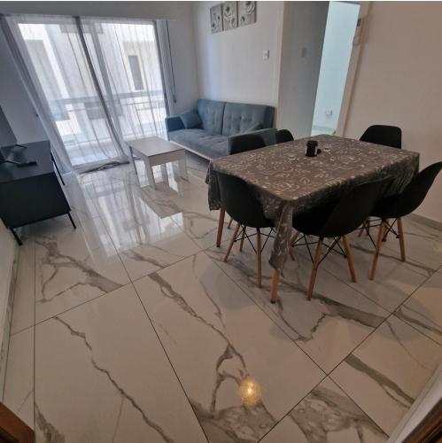 - un salon avec une table et un canapé dans l'établissement Cozy 1 bedroom apartment Larnaca city-center F, à Larnaka