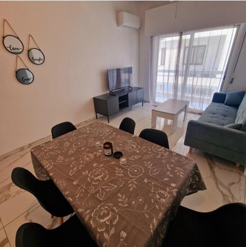 - un salon avec une table et un canapé dans l'établissement Cozy 1 bedroom apartment Larnaca city-center F, à Larnaka