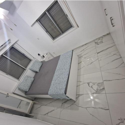 Cette chambre comprend un lit et deux fenêtres. dans l'établissement Cozy 1 bedroom apartment Larnaca city-center F, à Larnaka