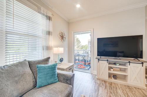 a living room with a couch and a flat screen tv at Gorgeous Calabash Condo with Balcony and Pool Access! in Calabash