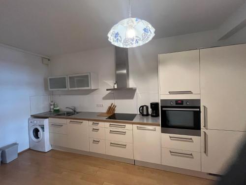 a kitchen with white cabinets and a chandelier at Waldshut -Kaiser55 in Waldshut-Tiengen