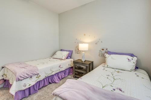 two beds in a room with purple and white at Gorgeous Calabash Condo with Balcony and Pool Access! in Calabash