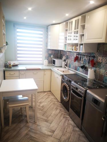 a kitchen with white cabinets and a table and a stove at Mieszkaj po Królewsku in Racibórz