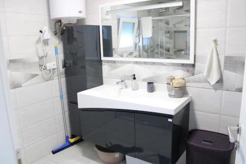 a white bathroom with a sink and a mirror at AM Una Lux House in Bihać
