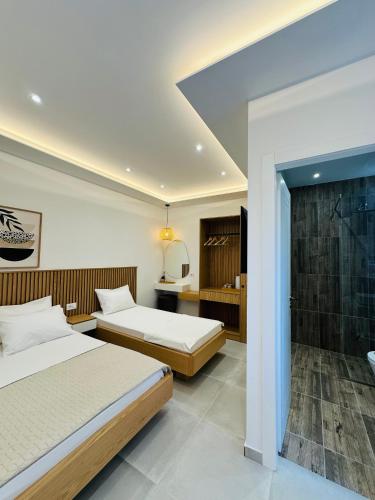 two beds in a hotel room with a bathroom at Potami Seashell in Himare