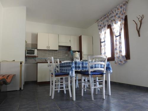 a kitchen with a table and chairs and a kitchen with a refrigerator at cala di seta in Calasetta