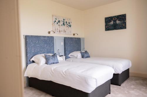 duas camas num quarto com lençóis brancos em The Mallard Hotel em Gullane