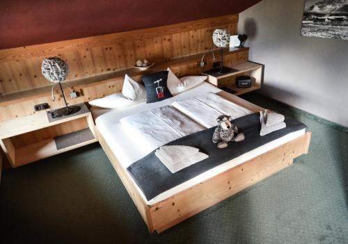 una cama de madera con un osito de peluche sentado en ella en Hotel Ehrwalderhof, en Ehrwald