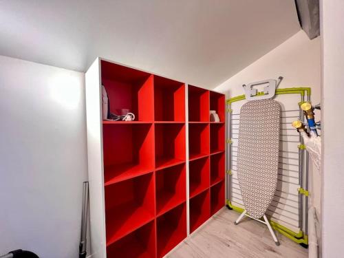 LE CLOS CHASSAING N5-WiFI-CENTRE VILLE-CLIMATISATION في بيريجو: غرفة بها رفوف حمراء ومبرد بداخلها