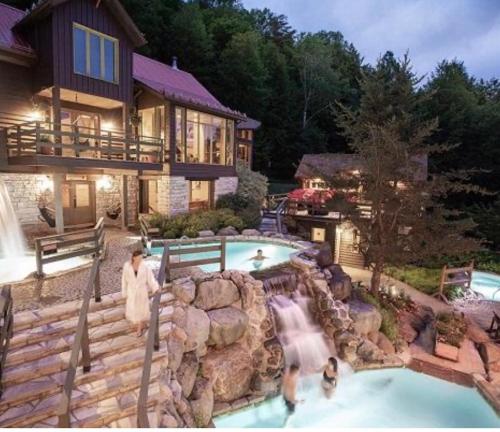 a house with a swimming pool with a waterfall at Tremblant Village Retreat!Steps to hill & trails in Mont-Tremblant