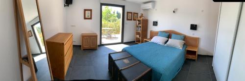 une chambre avec un lit avec une couverture bleue dans l'établissement VILLA NIMES BARTHEROES 3 Chambres, à Marguerittes