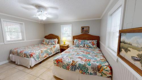 a bedroom with two beds and a painting on the wall at Family Time Lower by Tybee Vacation Rentals in Tybee Island