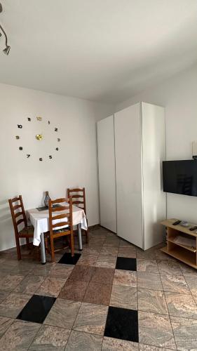 a dining room with a table and a clock on the wall at Villa Baldi -Apartmani Danny in Tar