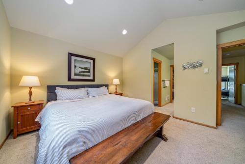 a bedroom with a large bed and a wooden bench at Sandpiper House-Manzanita Or in Manzanita