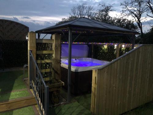 a hot tub in a gazebo on a fence at Spacious Lodge With Hot Tub in Lincolnshire