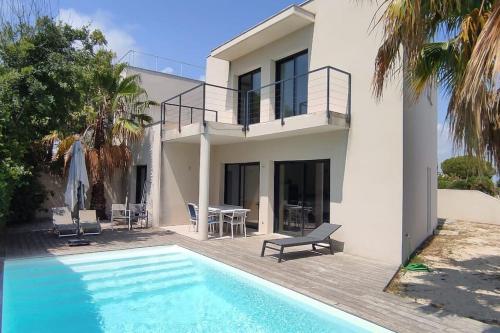 une maison avec une piscine devant une maison dans l'établissement Villa moderne près de la plage, à Villeneuve-lès-Maguelone