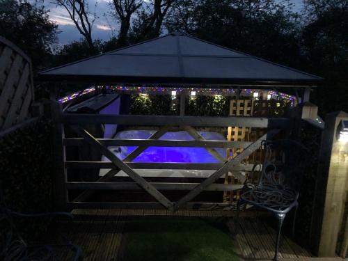 a gazebo with christmas lights on it at Spacious Lodge With Hot Tub in Lincolnshire