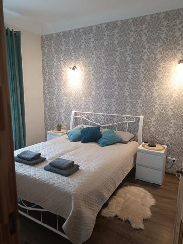 1 dormitorio con cama blanca y almohadas azules en Marta's Apartment, en Kuldīga