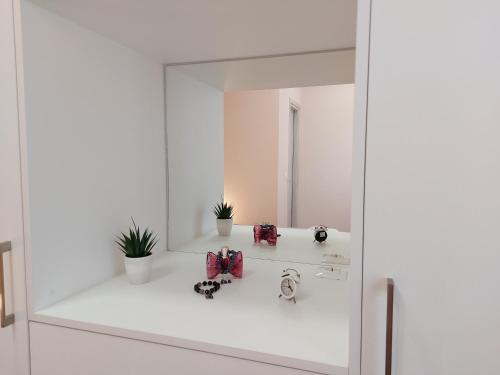 a white bathroom with a mirror and plants at La casetta di Emilia in Corfu Town