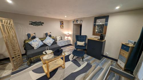 un salon avec un lit et une chaise dans l'établissement Studio 35m², Terrasse & Cuisine proche Carcassonne, à Montclar
