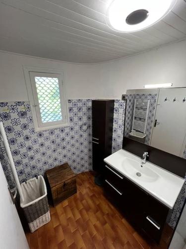 une salle de bain avec un lavabo et une fenêtre dans l'établissement Villa cosy, Porto-vecchio 150m mer, à Porto-Vecchio