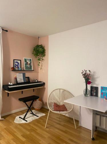 Cette chambre comprend un piano, une table et des chaises. dans l'établissement Studio neuf cozy avec balcon, 11e arr Voltaire, proche Bastille, à Paris