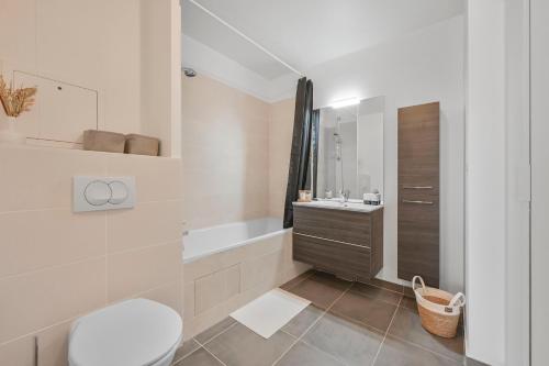 een badkamer met een bad, een toilet en een wastafel bij Appartement Chic au Coeur de Massy in Massy