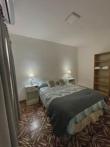 a bedroom with a large bed and two night stands at Los Geranios Apart in Villa Cubas