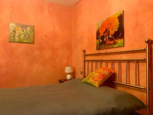 1 dormitorio con 1 cama y 2 cuadros en la pared en Spacious house with private garden in Chianti, en Lucolena in Chianti