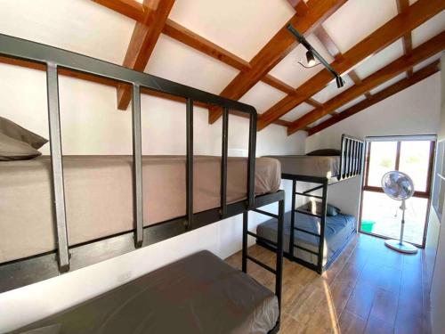 Habitación con 3 literas y techo con vigas. en Camelia Chincha® Hermosa Casa de Playa y Campo en San Pablo