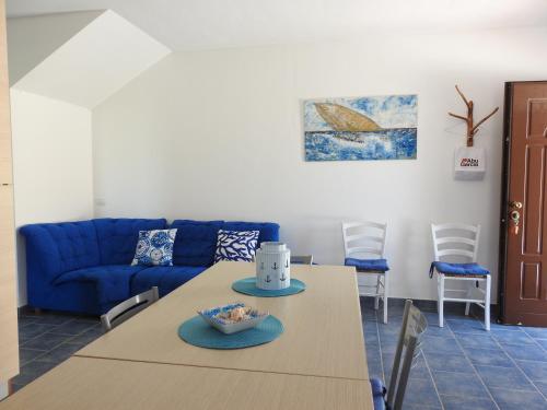 a living room with a table and a blue couch at cala di seta in Calasetta