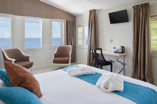 1 dormitorio con 1 cama con 2 sillas y escritorio en Hotel & Talasoterapia Zelai - HSS00653, en Zumaia