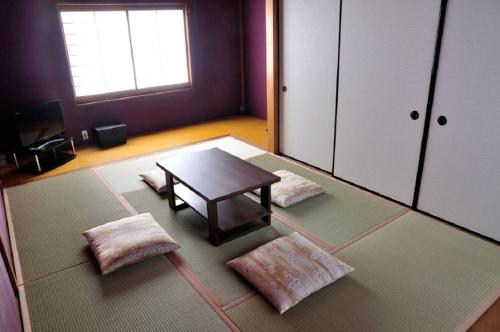 a living room with a table and two pillows at Minpaku KEN HOUSE - Vacation STAY 60948v in Nagahama
