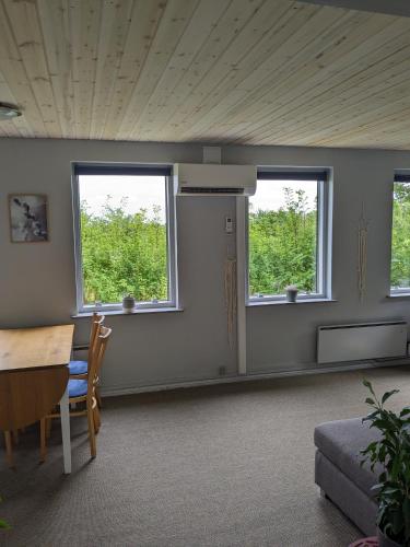 a room with two windows and a table and chairs at Landstedet in Gram
