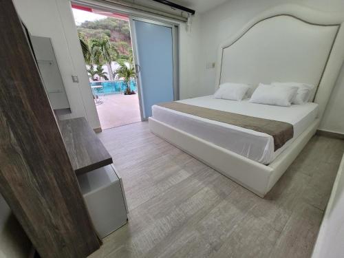 a bedroom with a large bed and a sliding glass door at Hotel Med Taganga in Taganga